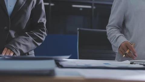 Two accountants examining financial documents using a calculator, taking no.. Stock Footage 336017321
