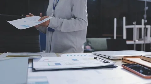 Two accountants examining financial documents using a calculator, taking no.. Stock Footage 336017345