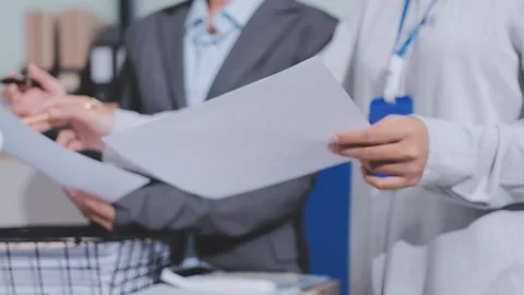 Two accountants examining financial documents using a calculator, taking no.. Stock Footage 336017778