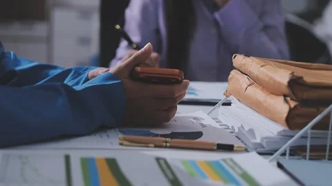 Two accountants examining financial documents using a calculator, taking no.. Stock Footage 336018928