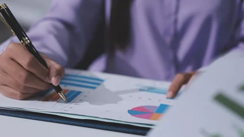 Two accountants examining financial documents using a calculator, taking no.. Stock Footage 336020441