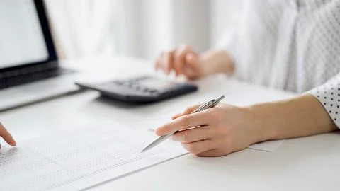 Two accountants using a laptop computer and calculator for counting taxes at Foto stock