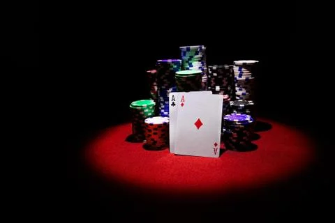 Two aces with gambling chips on red casino table Stock Photos