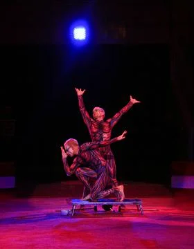 Two acrobats with makeup on their faces are posing 스톡 사진