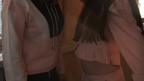 Two active sisters in hats and headphones listening music Video stock 108567028