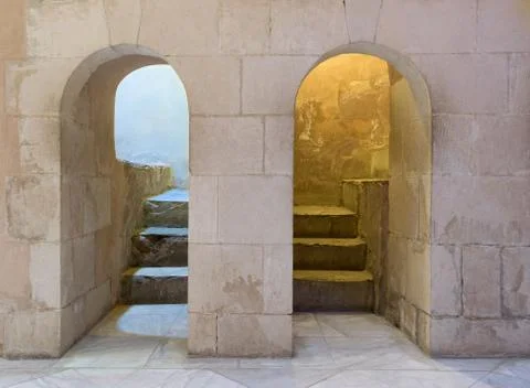 Two adjacent aged narrow dark vaulted passages and stone bricks wall Stock Photos