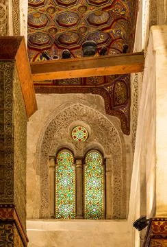 Two adjacent perforated stucco arched windows with colorful stain glass patterns Stock Photos