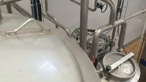 Two adjacent vessels of different sizes, interconnected by pipes. Equipment Stock Footage 127742524