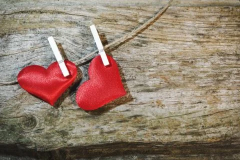 Two adorable red hearts on string with clothes pegs on wooden background Stock Photos