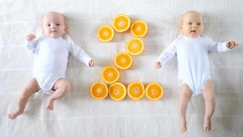 Two Adorable Two-Month-Old Twin Babies Lying Together. Positive Lifestyle 스톡 사진