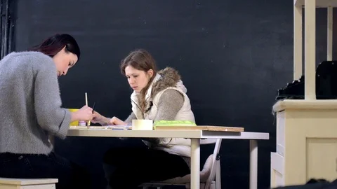 Two adult women paint with colored acrylic paints in an art school Stock Footage 87583553