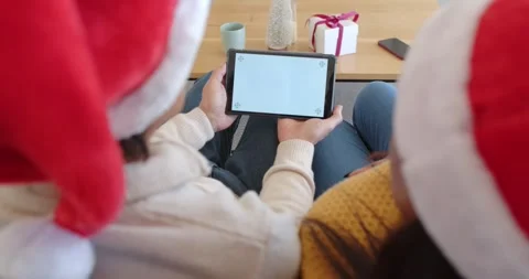 Two adults are sharing tablet focus on couch, camera is moving up revealing Stock Footage 346614525