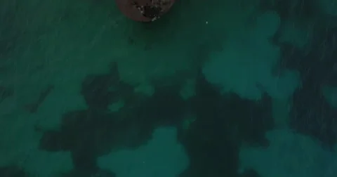 Two aerial shots passing over an old shipwreck in clear green waters Stock-Footage 66420574