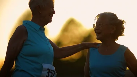 Two affectionate elderly friends smile and chat together after participating in Stock-Footage 88406636