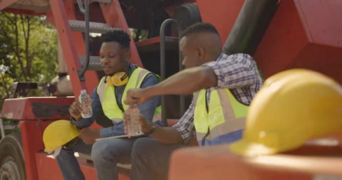 Two African American construction workers Happy sit forklift drink water Видео 166841653