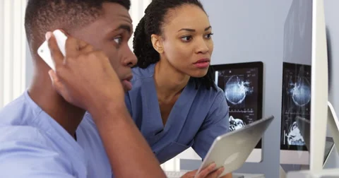 Two African American doctors using tablet and phone to work together Video stock 42670071