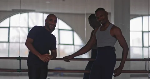 Two african-american men looking posing holding barre on dance studio Stock Footage 147357686