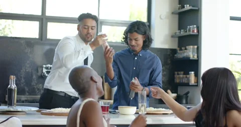 Two African American men passing shaker, sprinkling spice into bowl after pass Stock Footage 344333741