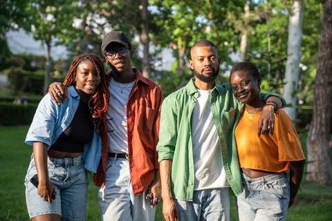 Two African American student couples in love stand in park while walking Stock Photos