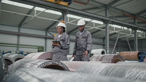 Two African American workers counting industrial objects or constructions in Stock Footage 255669158