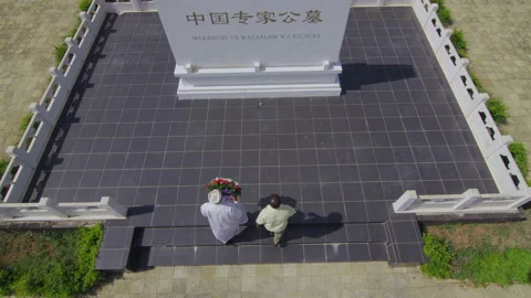 Two African old men lay wreaths at Chinese expert cemetery,   Tanzania  Africa Stock Footage 132429895