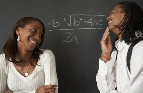 Two African students next to math problem on blackboard Stock Photos