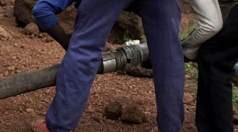 Two African workers connect the large tubes for petrol. Stock Footage 67431352
