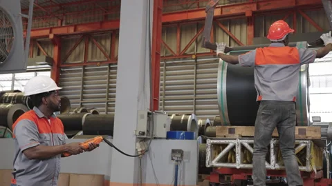 Two African workers work together to bring steel hooks to lift the sheet rolls. Stock Footage 175583389
