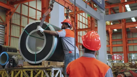 Two African workers work together to bring steel hooks to lift the sheet rolls. Stock Footage 175584796