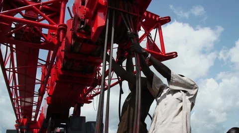 Two Africans working at a mechanical lift, mobile crane. Stock Footage 65870188