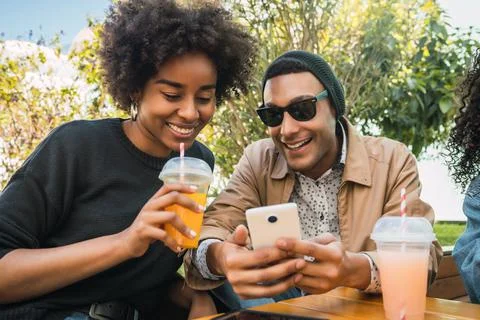 Two Afro friends using their mobile phone. Stock Photos