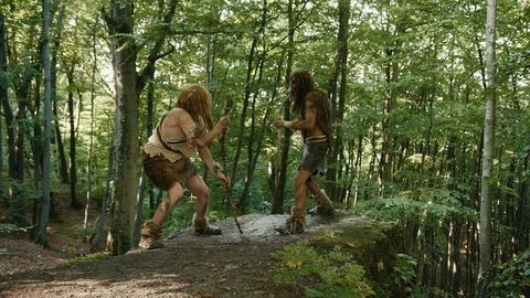 Two aggressive wildmen of neanderthals with sticks fighting for tribe leadership Stock Footage 116632923