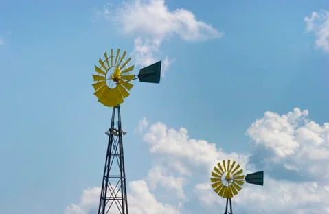 Two agriculture wind mills and cloudy sky Stock Photos