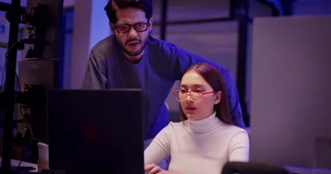 Two AI developers working late night on machine learning code in tech office Stock Footage 310483752