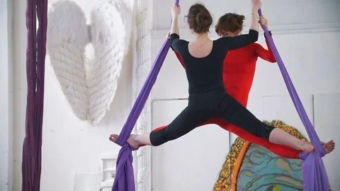 Two air gymnast doing gymnastic elements on aerial silk Stock Footage 87981160