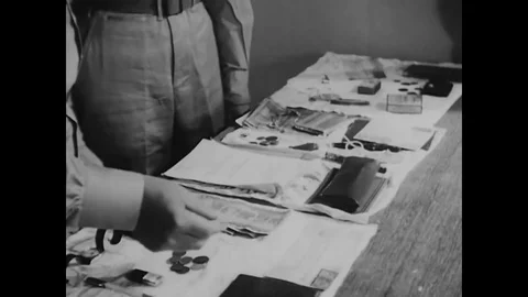 Two Air Interrogation Officers look at the personal belongings (including a Stockbeeldmateriaal 83163955