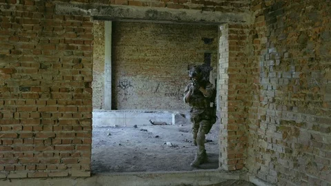 Two air soft men go through door hole training fight in urban territory. Video stock 127884093