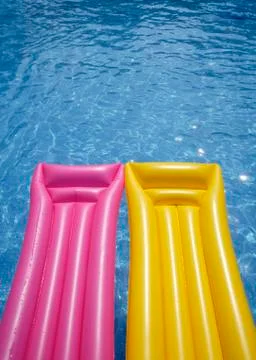 Two airbeds floating in pool, elevated view Stock Photos