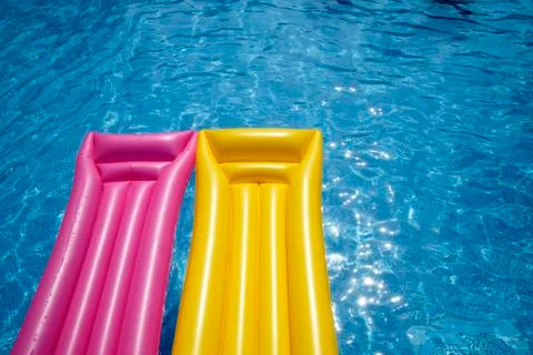 Two airbeds floating in pool, elevated view Foto stock