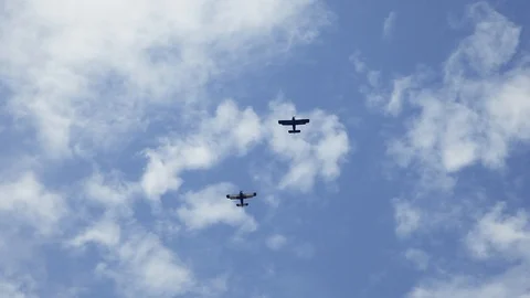 Two aircraft fly over head against cloudy blue sky Stock Footage 123254075