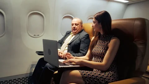 Two airline passengers using a laptop in-flight, showcasing onboard WiFi. Stock-Footage 310232846