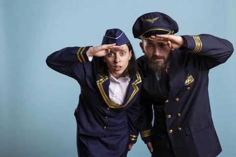 Two airline pilots lean forward to look into far distance Stock Photos