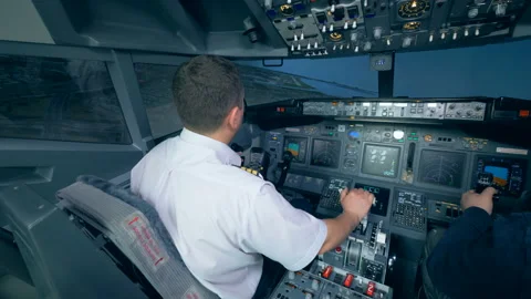 Two airmen in flight simulator, holding helms in a cockpit. 4K. Stock Footage 88590254