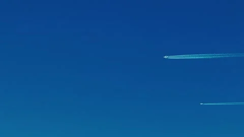 Two airplanes flying across a clear blue sky Stock Footage 324574273