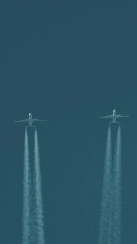 Two airplanes flying together leaving contrails in the blue sky Video stock 327415089