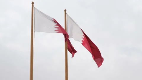 Two Al-Adaam national flags of Qatar flying in the sky above Doha, Qatar Stock Footage 169747861