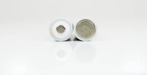 Two alkaline batteries on a white background with reflection. Energy supply a Stock Photos
