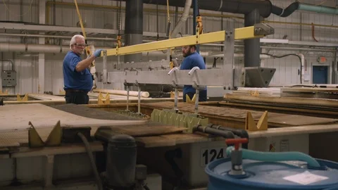 Two American workers use gantry cranes to lower steel components into a Stock-Footage 115699852
