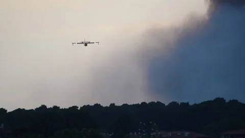 Two amphibious water bombers dropping water on forest fire. Stock Footage 142591364
