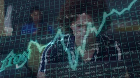 Two analysts watching screens, typing as code streams appearing and chart rising Stock Footage 334703249